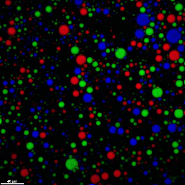 Pequenos círculos coloridos em vermelho, azul ou verde contra um fundo preto