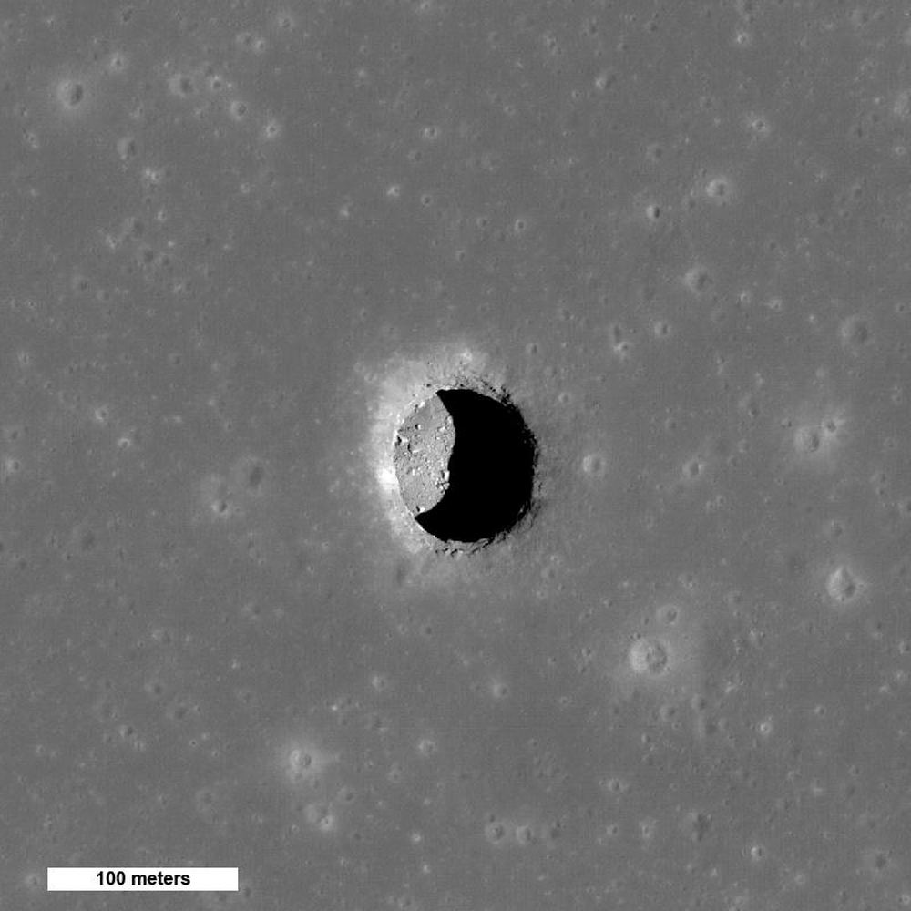 Vista espetacular do sol alto da cratera Mare Tranquillitatis revelando pedras em um chão liso. O poço de 100 metros pode fornecer acesso a um tubo de lava lunar. Crédito da imagem: Por NASA/GSFC/Arizona State University - http://photojournal.jpl.nasa.gov/catalog/PIA13518, Domínio Público, https://commons.wikimedia.org/w/index.php?curid=54853313