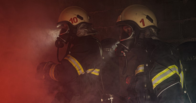 Bombeiros na sala cheia de fumaça